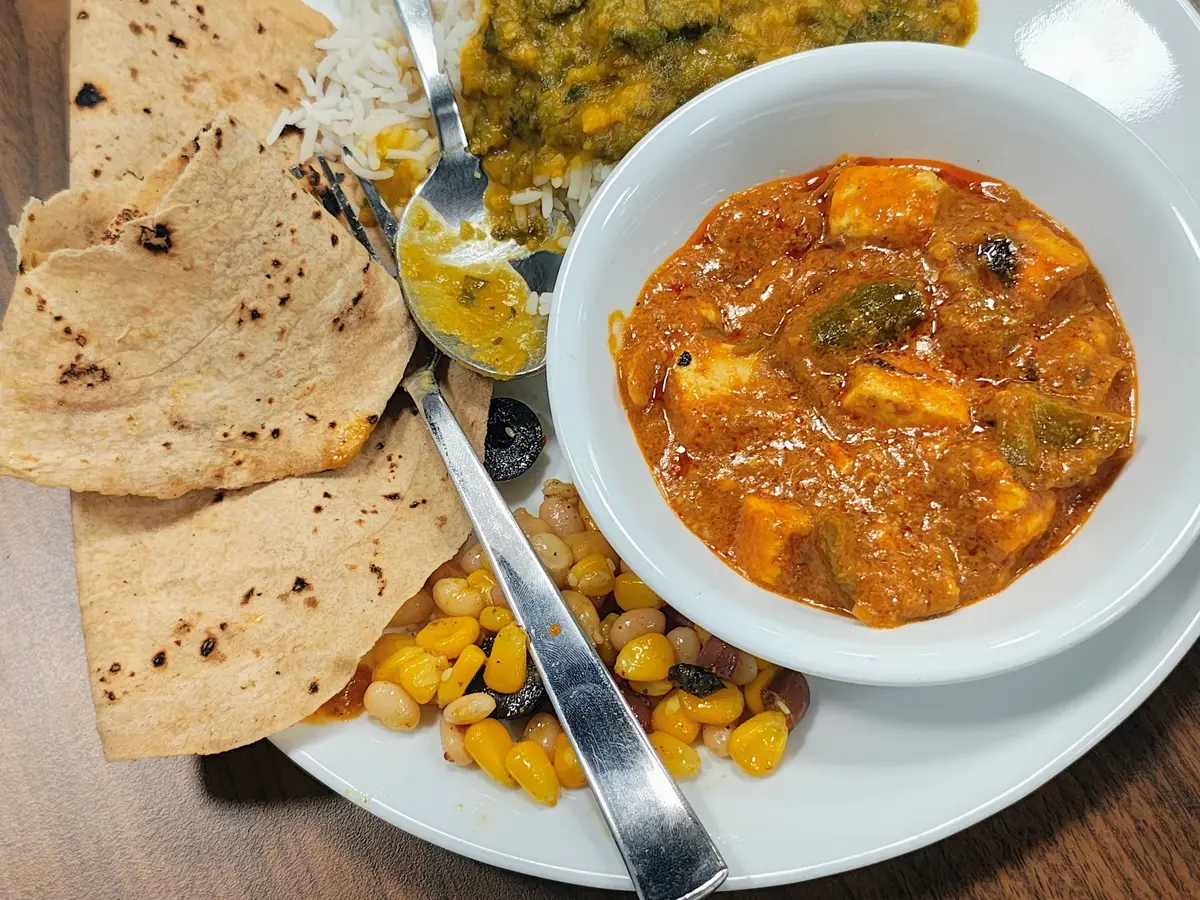 Lentejas al curry sobre arroz con curry de queso fresco y pan naan