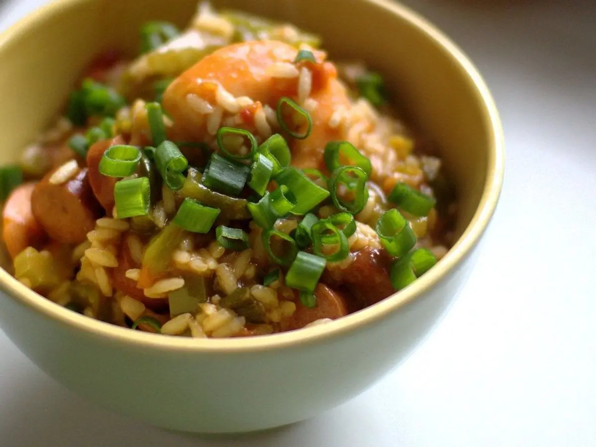 Cuenco amarillo de arroz con gambas, cebolleta picada y verduras