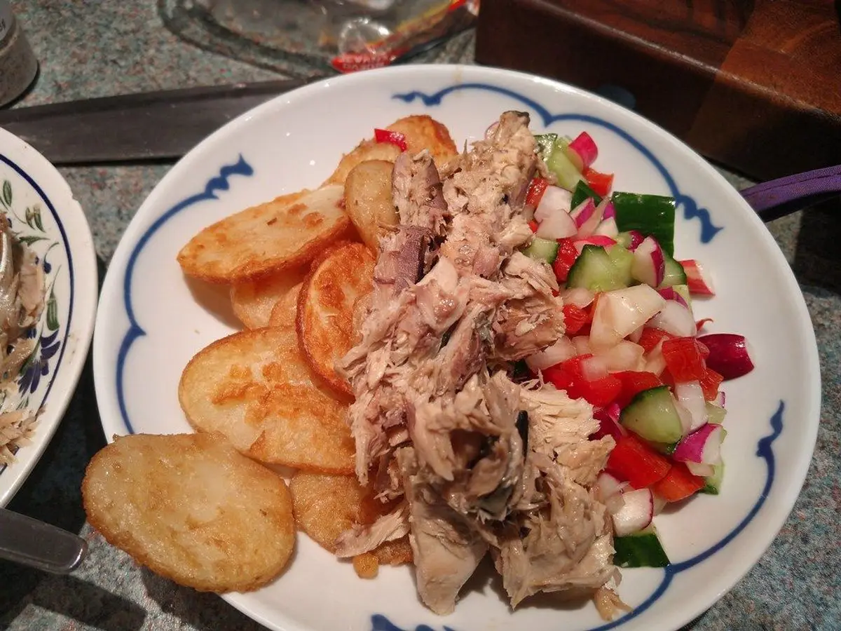 Plato con pescado, ensalada y patatas crujientes