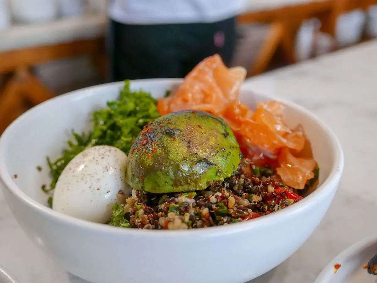 Bol blanco de quinoa con huevo cocido, aguacate, kale y verduras