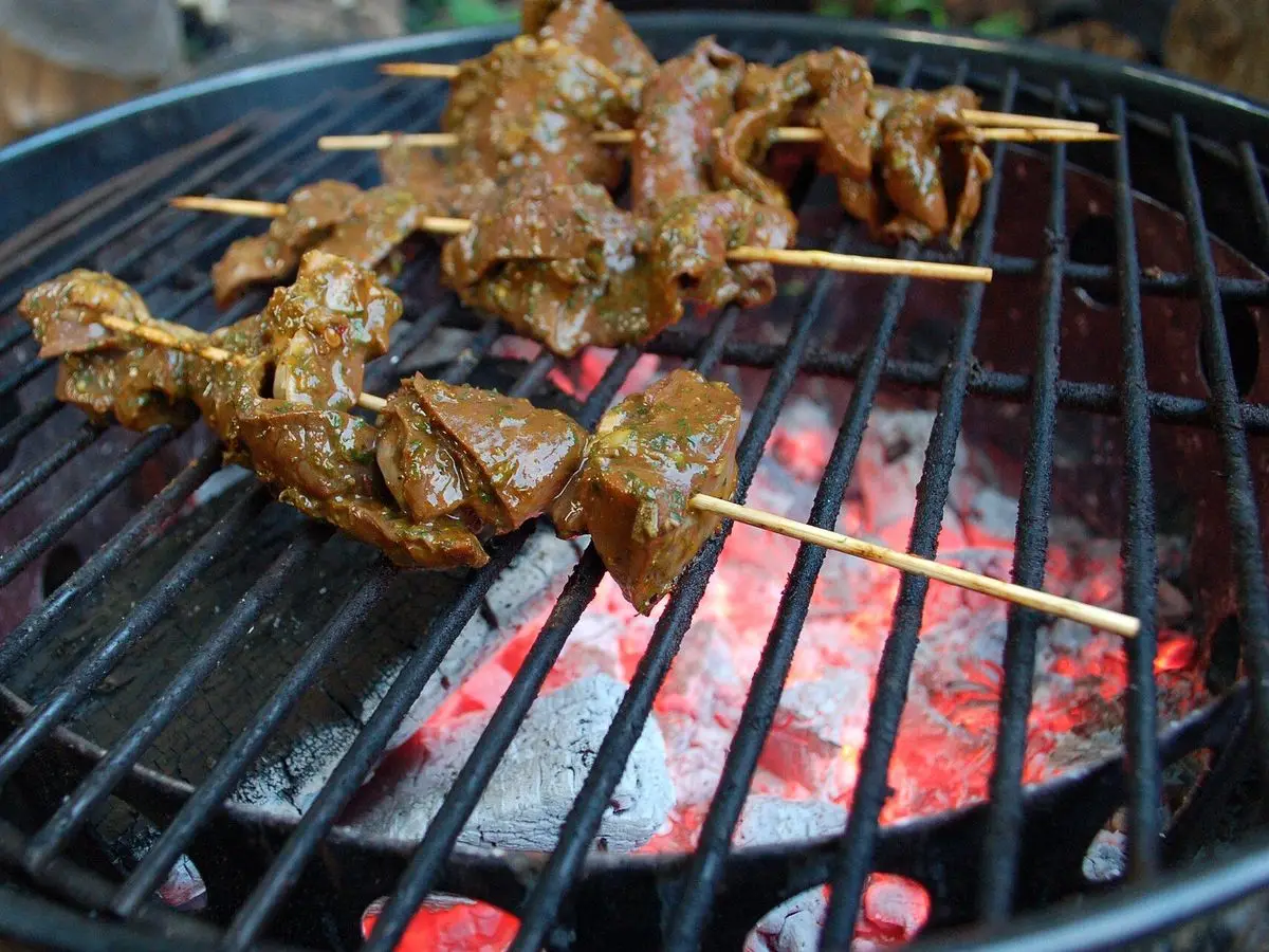 Brochetas de carne de ternera asándose sobre las brasas de una barbacoa
