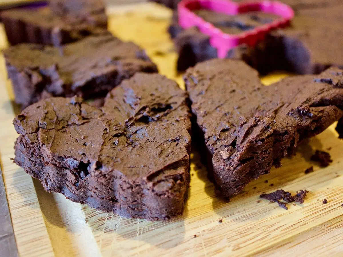 Brownies de chocolate cortados en forma de corazón sobre una tabla de madera