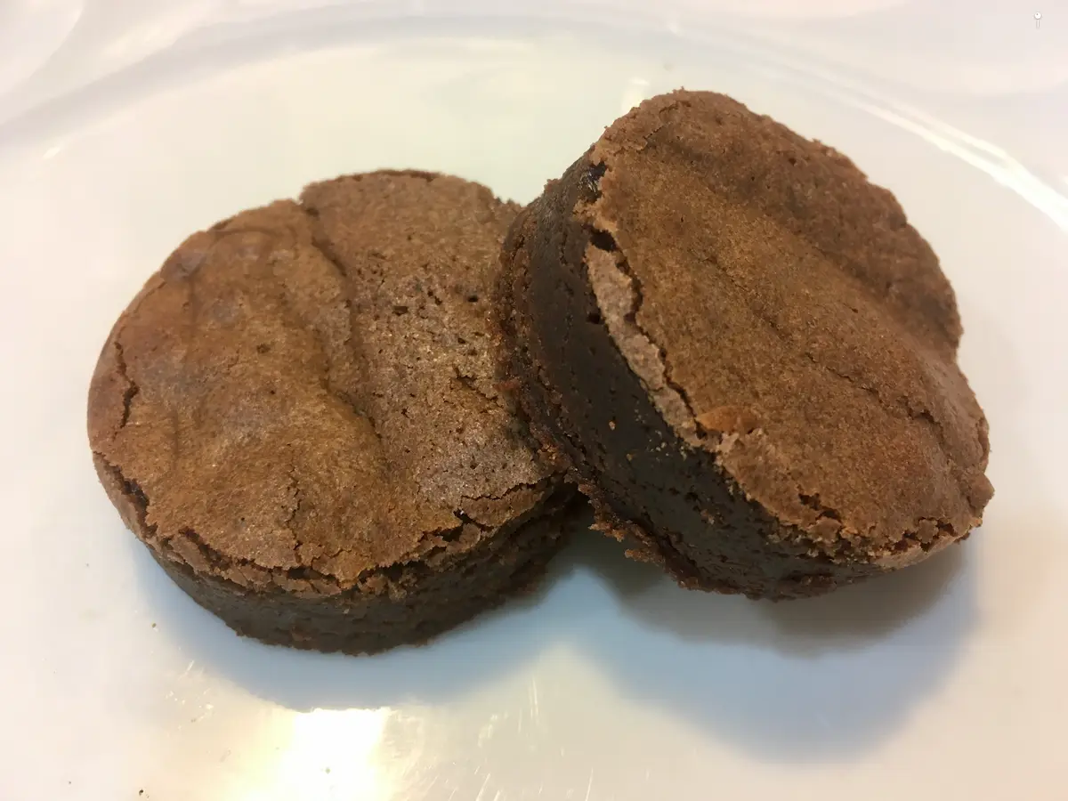 Dos brownies de chocolate redondos sobre un plato blanco