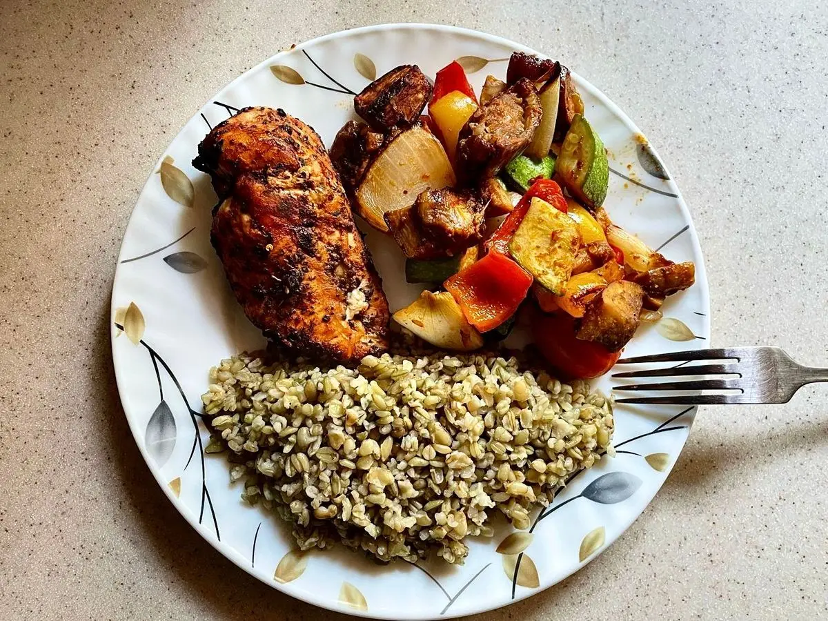 Plato con carne a la plancha, verduras salteadas con pimiento y una ración de bulgur