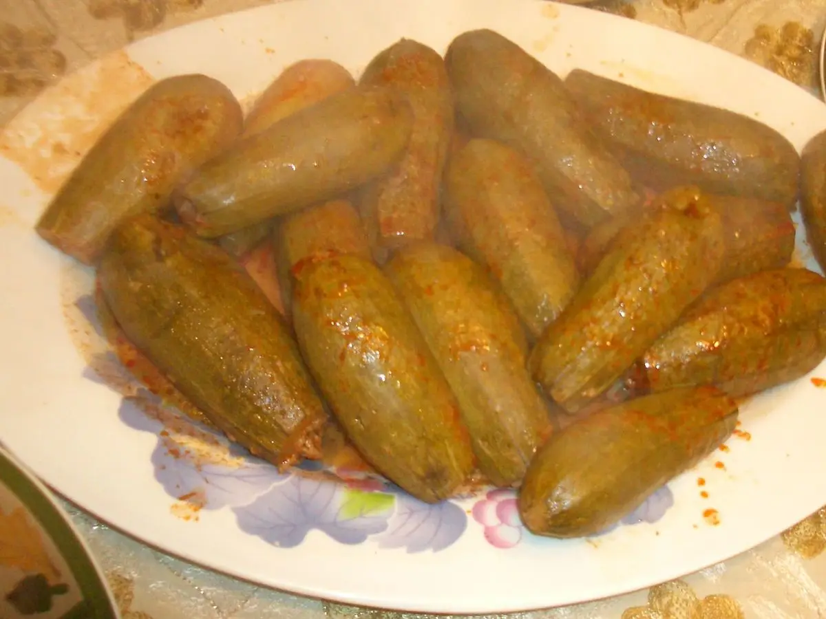 Fuente ovalada con calabacines rellenos cocinados en salsa de tomate