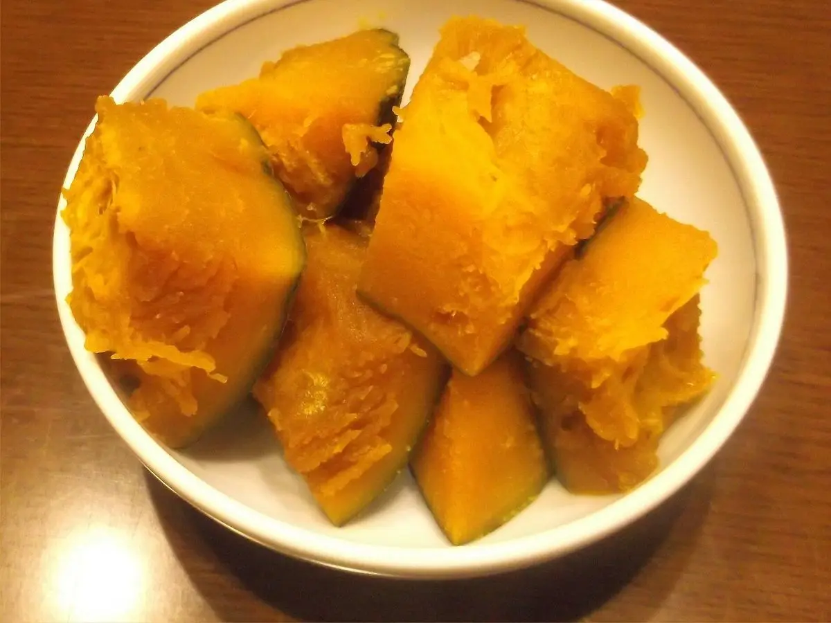 Cuenco blanco con trozos de calabaza kabocha guisada a la japonesa, tiernos y brillantes
