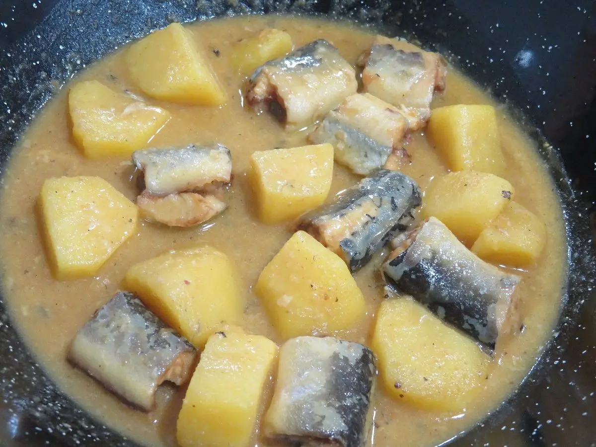 Cazuela con rodajas de pescado de piel oscura y dados de patata guisados en salsa