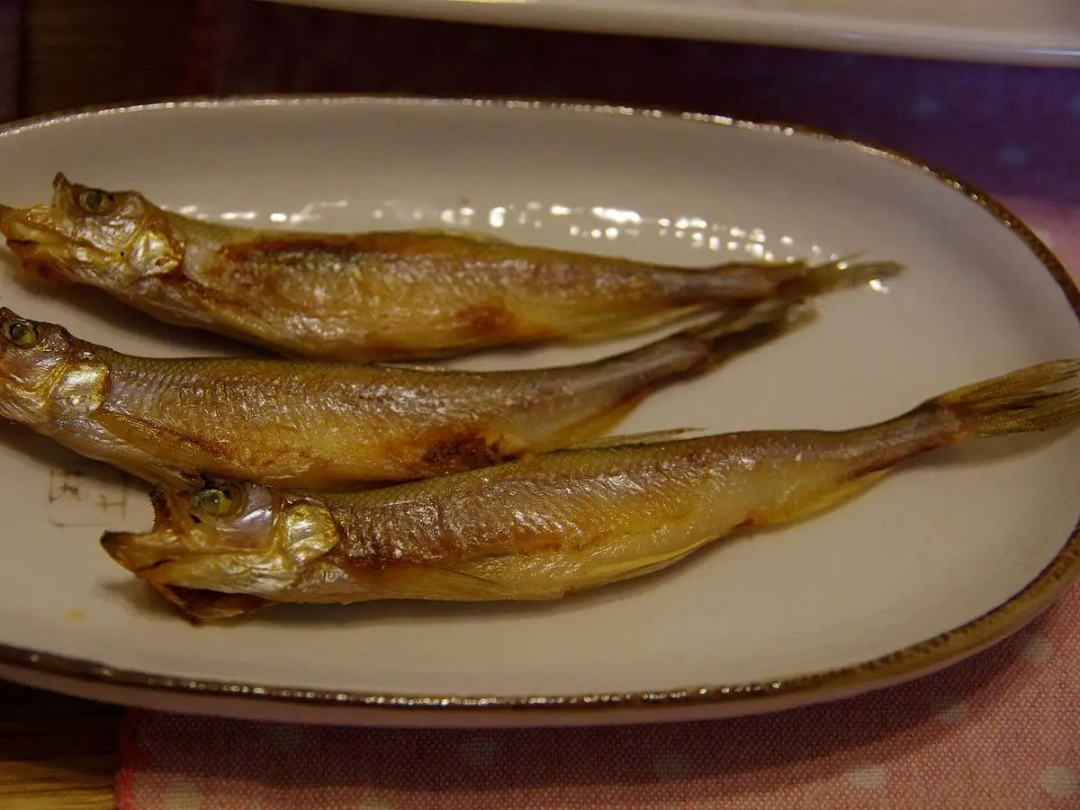 Tres capelanes asados al estilo shishamo servidos en un plato ovalado
