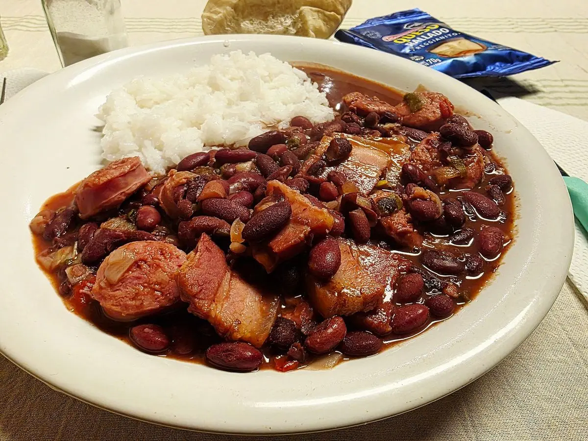 Plato con alubias rojas guisadas con costilla y rodajas de embutido junto a arroz blanco