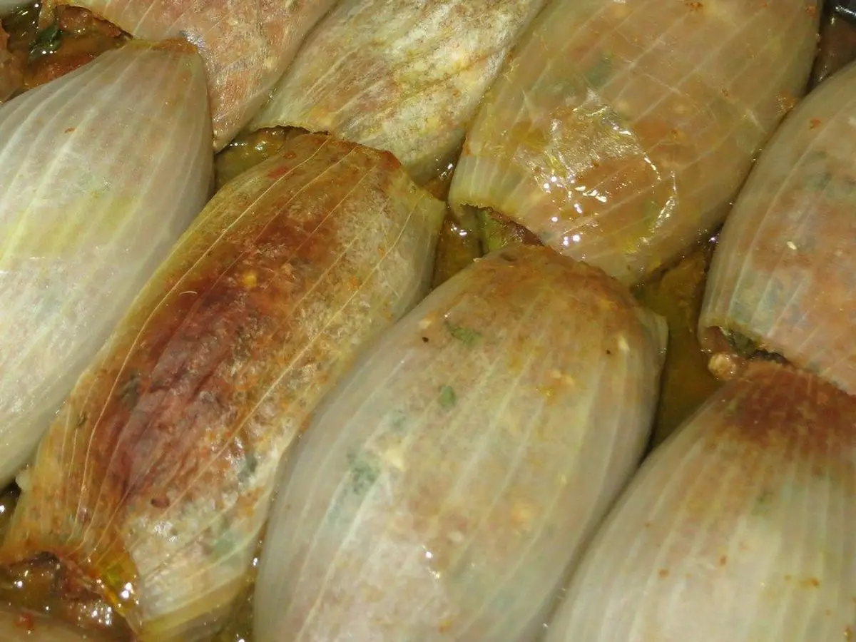 Cebollas enteras asadas y doradas en una fuente de horno