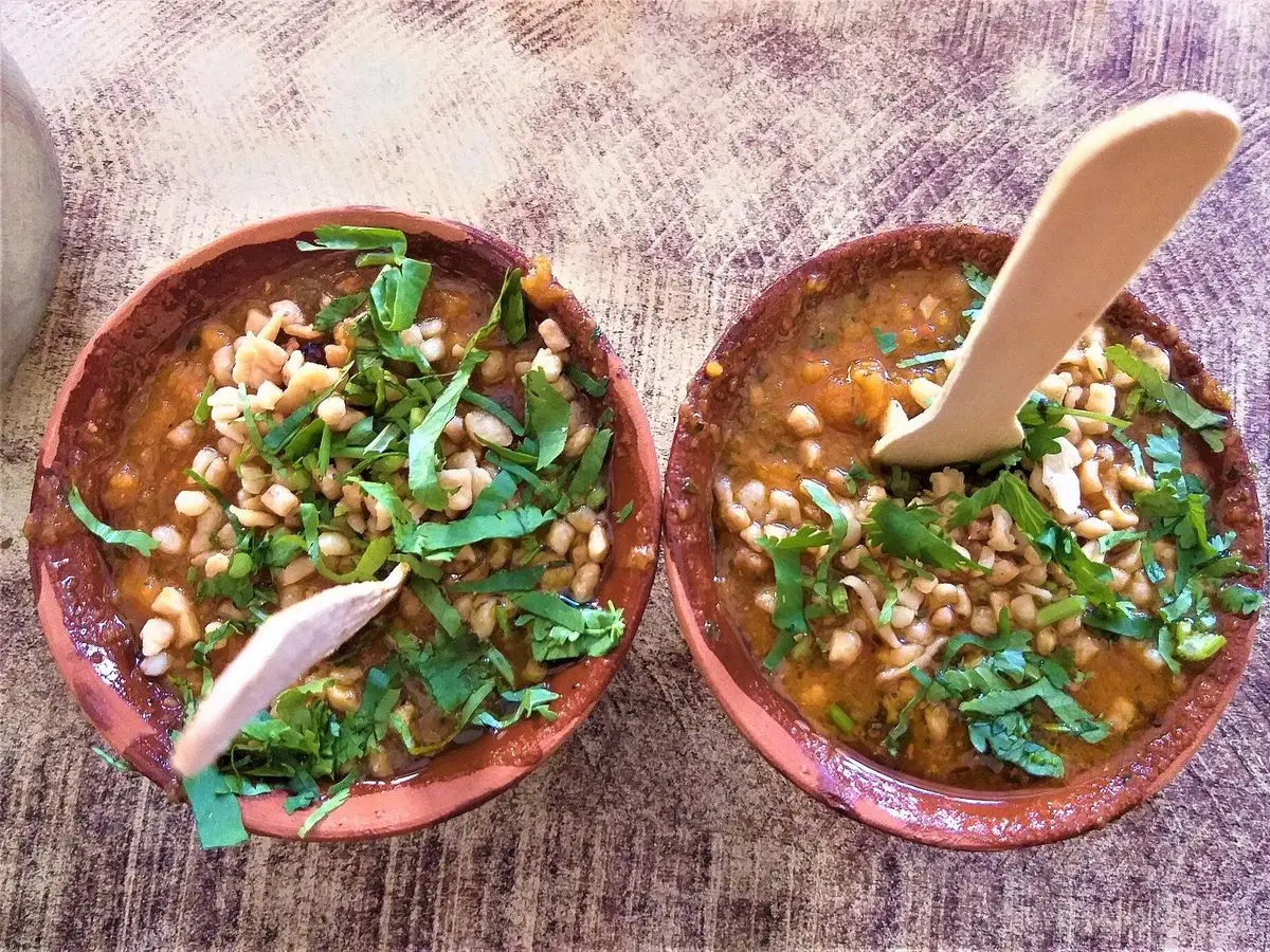 Dos cuencos de barro con legumbres, hierbas frescas y verduras al estilo de chaat indio
