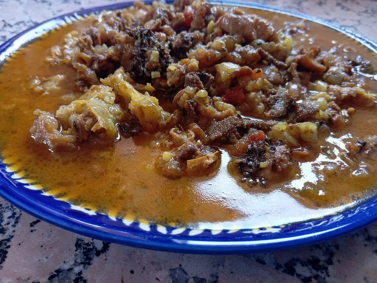 Plato con guiso de menudillos troceados en salsa anaranjada