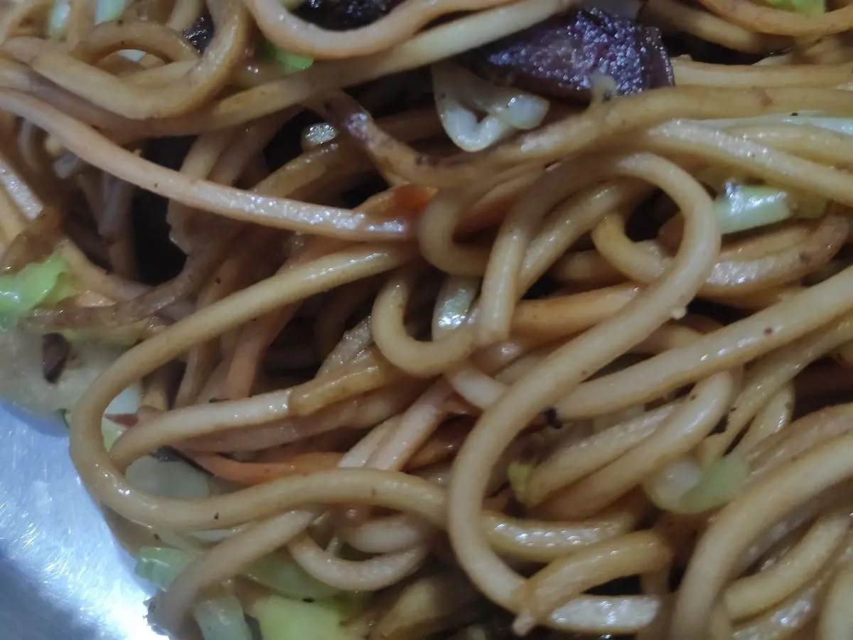 Fideos chow mein salteados con tiras de ternera y verduras en un plato