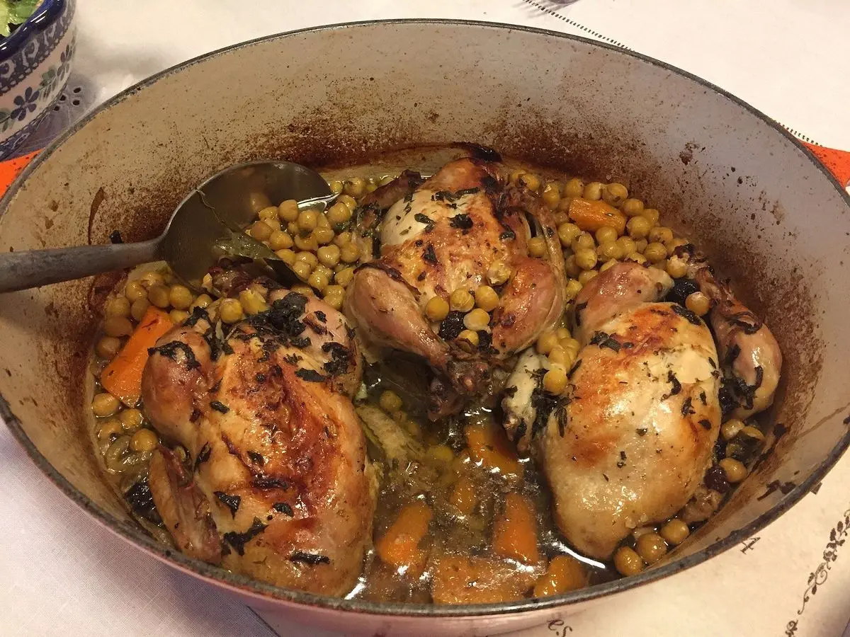 Cazuela de hierro con codornices guisadas con garbanzos, zanahoria y cebolla