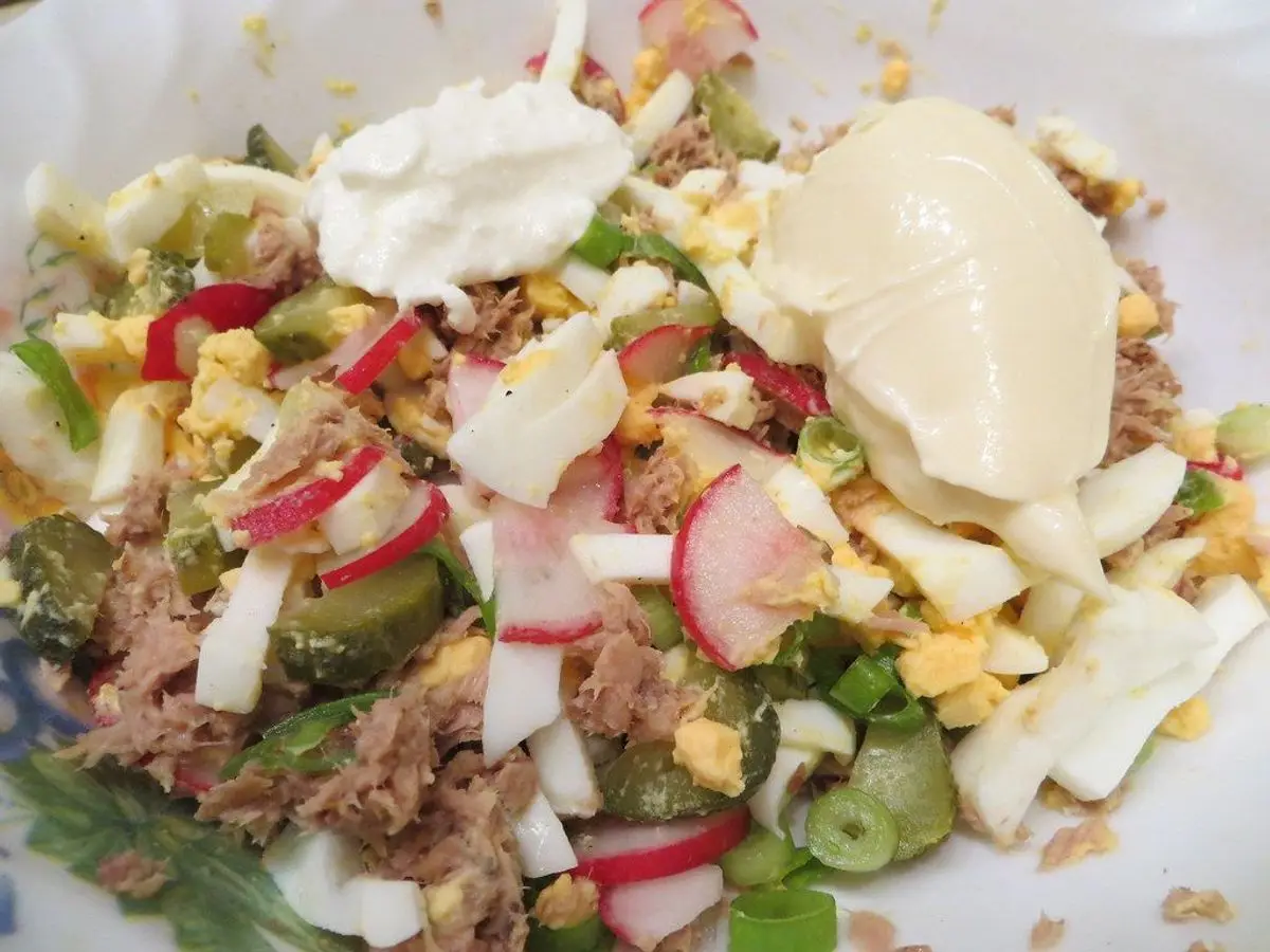 Ensalada de lechuga con atún, huevo duro, rábano y mayonesa en un plato