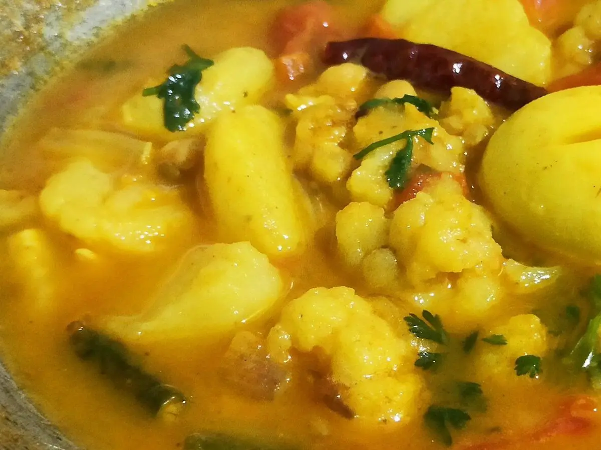 Guiso de coliflor, patata y huevo cocido con especias en salsa amarilla