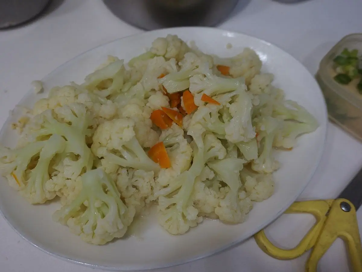 Plato blanco de coliflor salteada con tiras de zanahoria