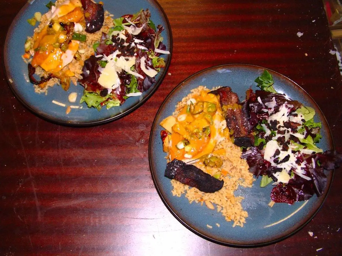 Dos platos azules con ensalada de col lombarda y verduras asadas con carne