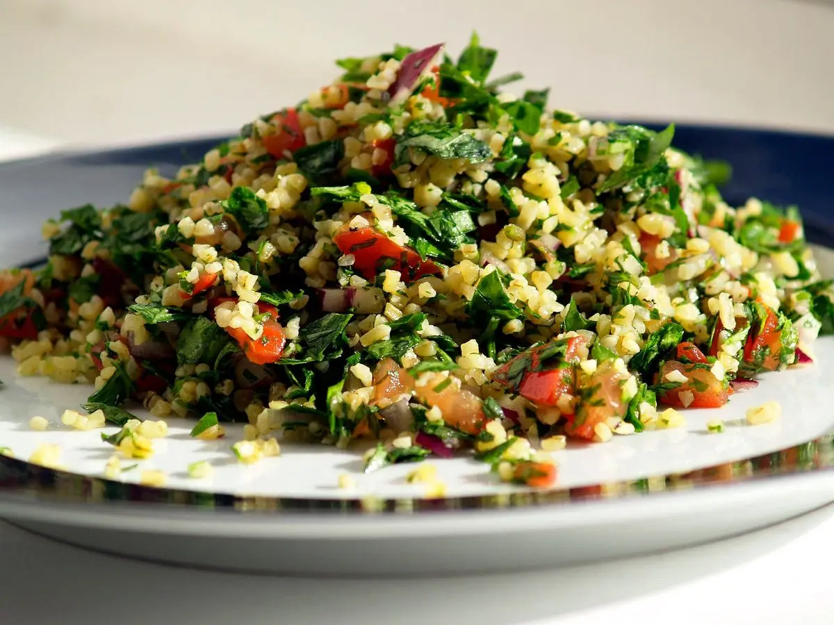 Plato de tabulé con perejil, tomate y bulgur