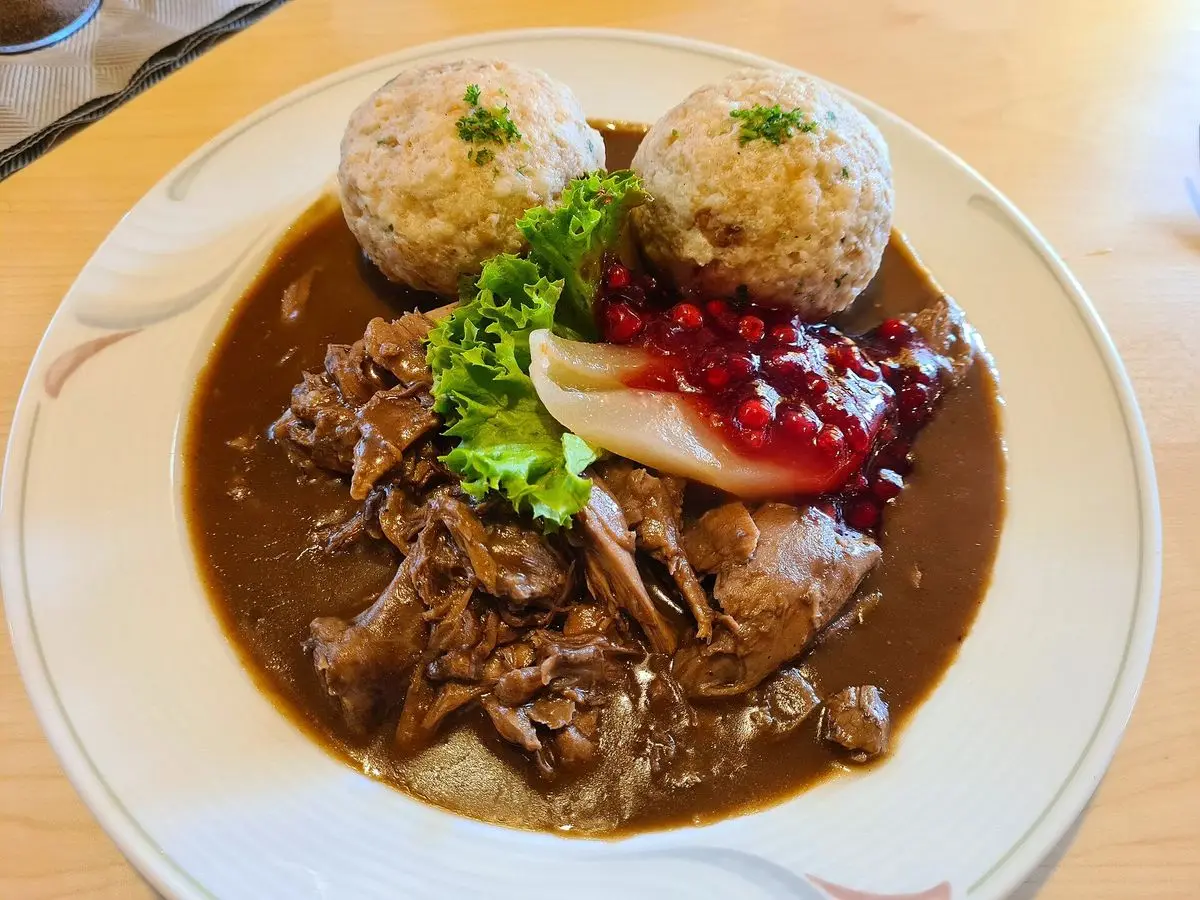 Estofado de corzo en salsa oscura con albóndigas de pan, arándanos rojos y lechuga