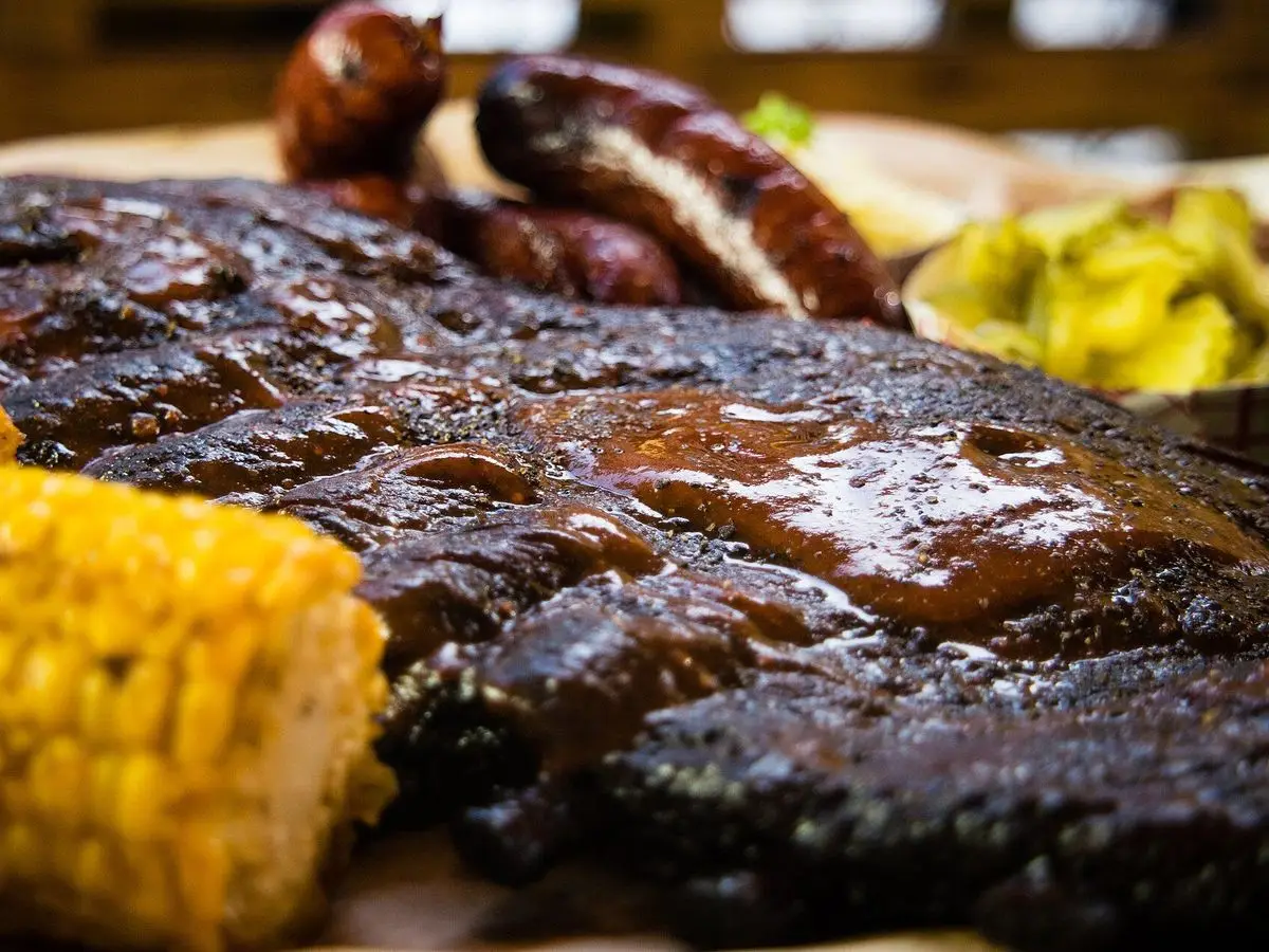 Costillas de cerdo glaseadas a la brasa con salsa barbacoa y mazorca de maíz dulce asada