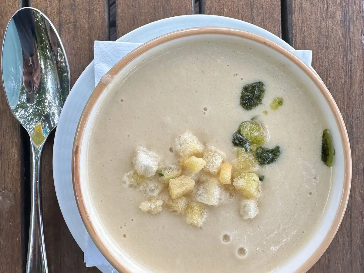 Crema de verduras con picatostes y aceite de hierbas en un cuenco