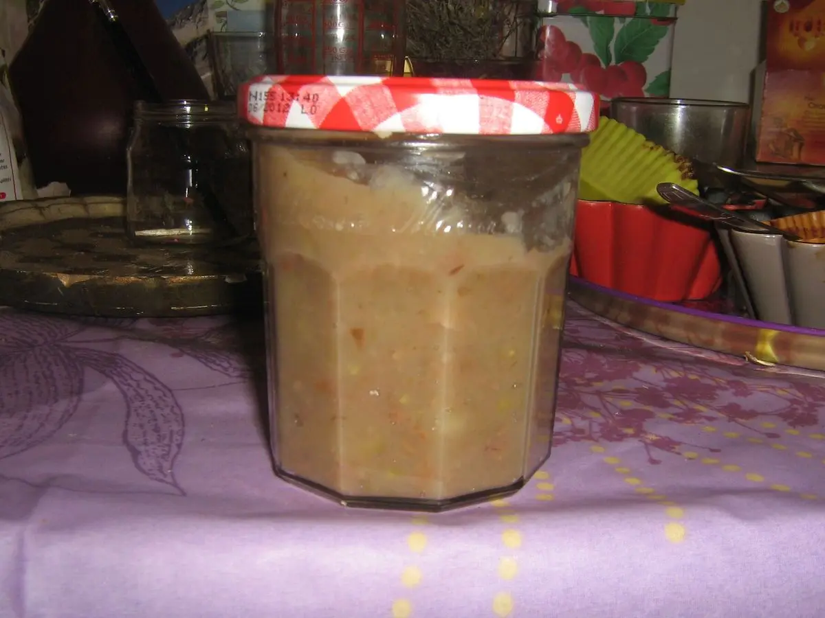 Tarro de cristal con tapa roja lleno de crema marrón de castañas