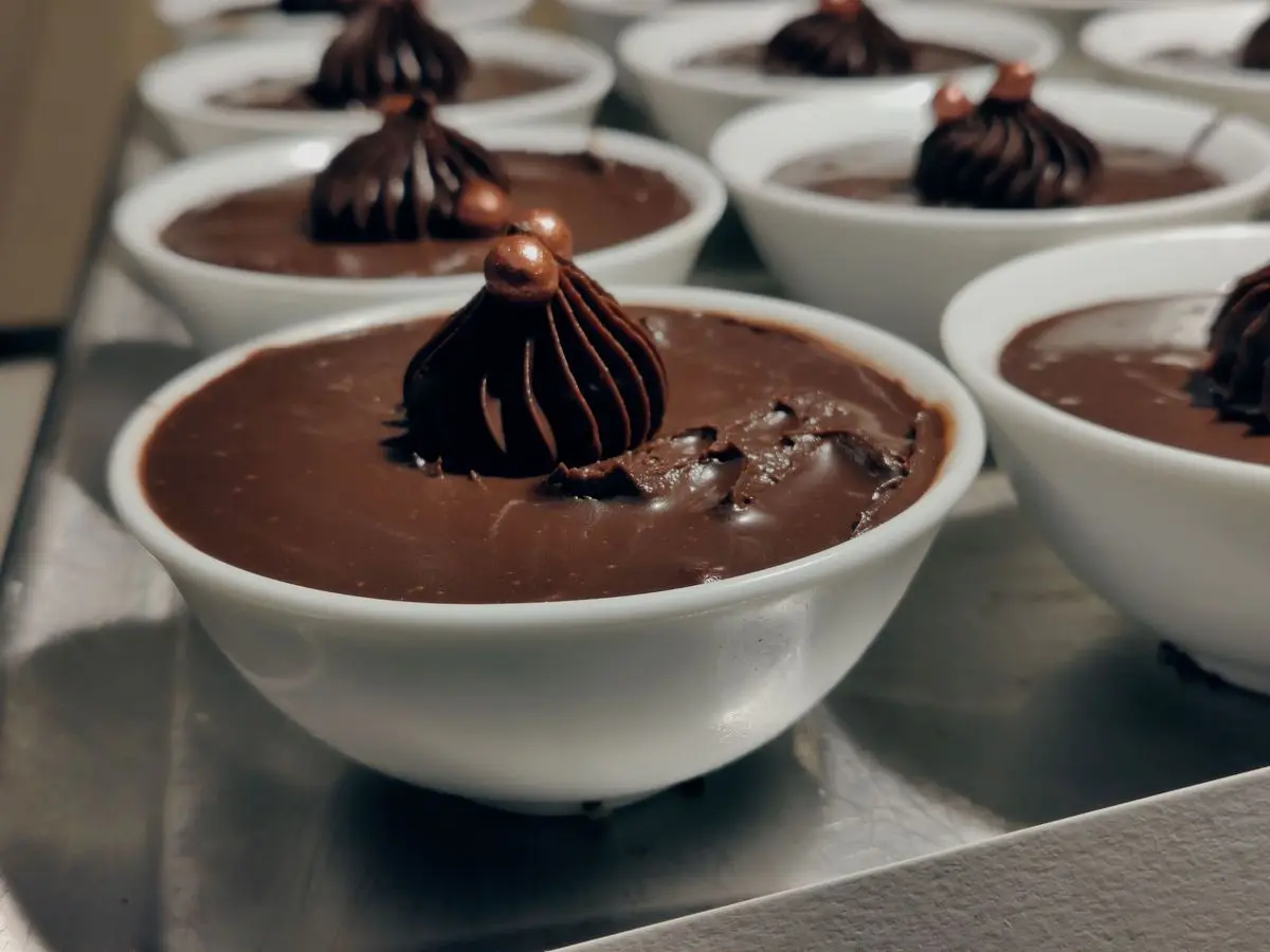 Cuencos blancos de crema de chocolate coronados con un adorno de chocolate en espiral
