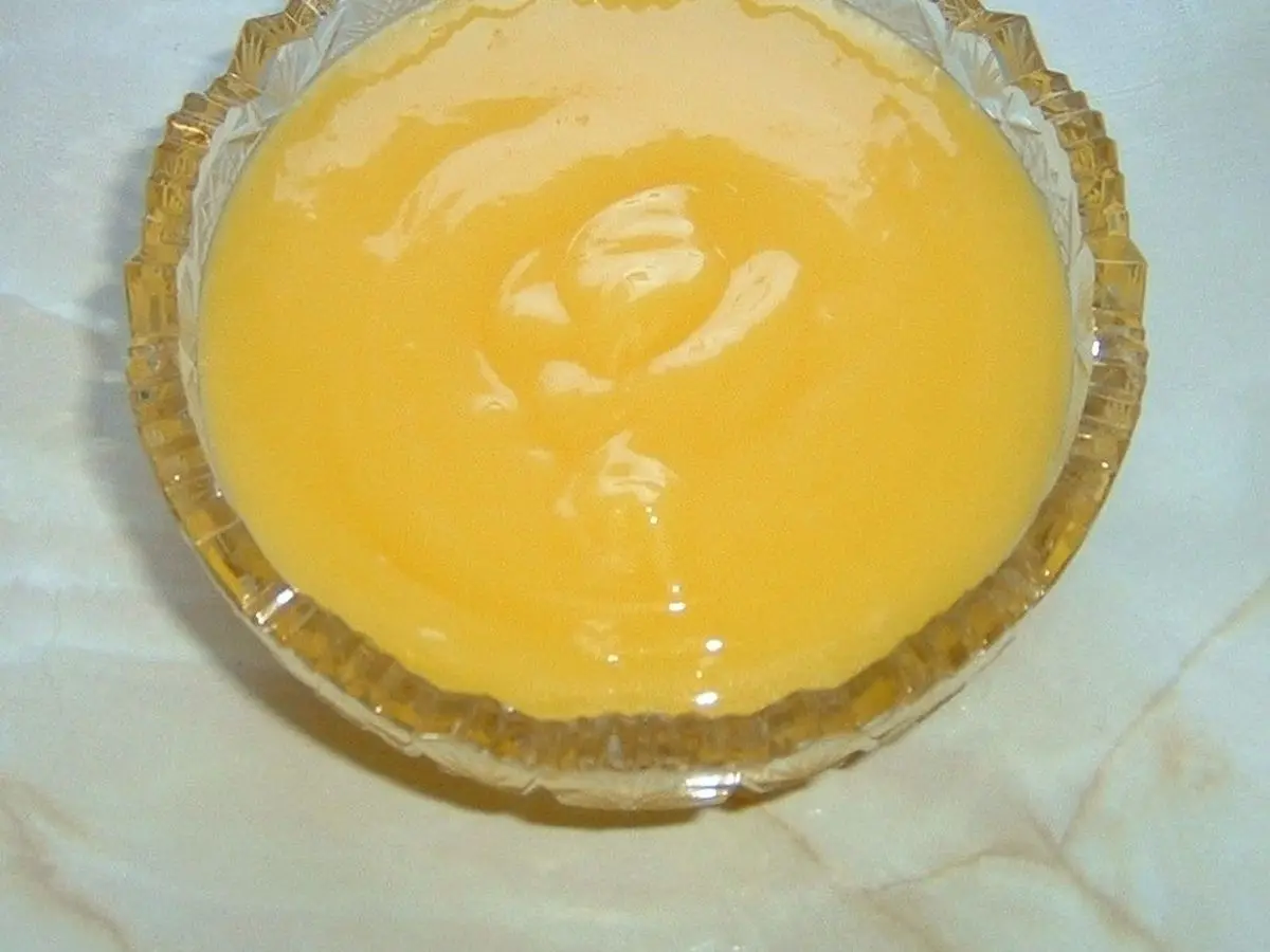 Cuenco de cristal con crema de limón amarilla, lisa y brillante