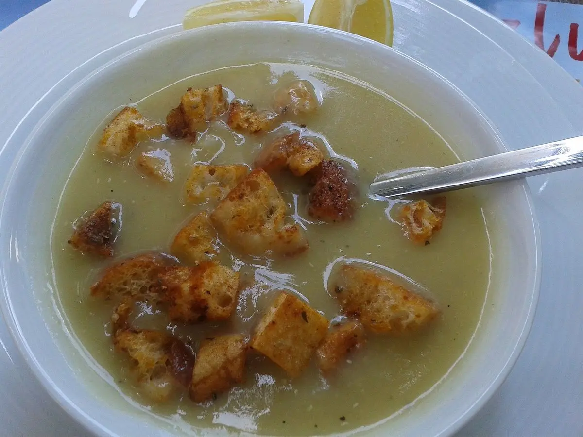 Cuenco de crema de verduras con picatostes dorados y una cuchara