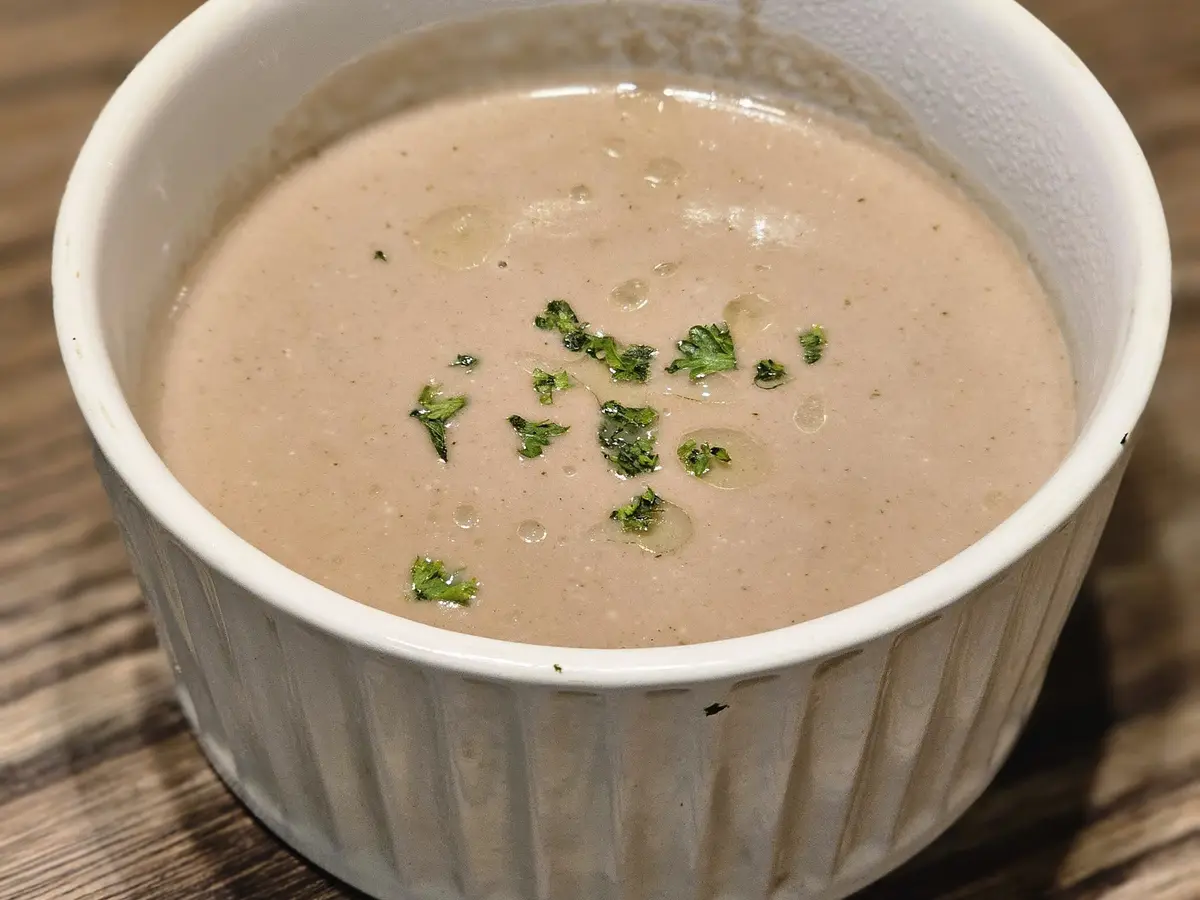 Crema de verduras con perejil picado en un cuenco blanco