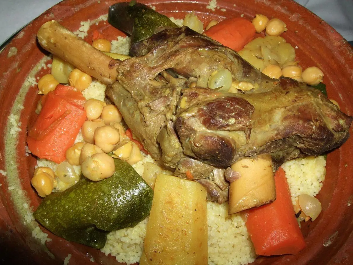 Cuscús con paletilla de cordero, zanahoria, calabacín, nabo y garbanzos en plato de barro