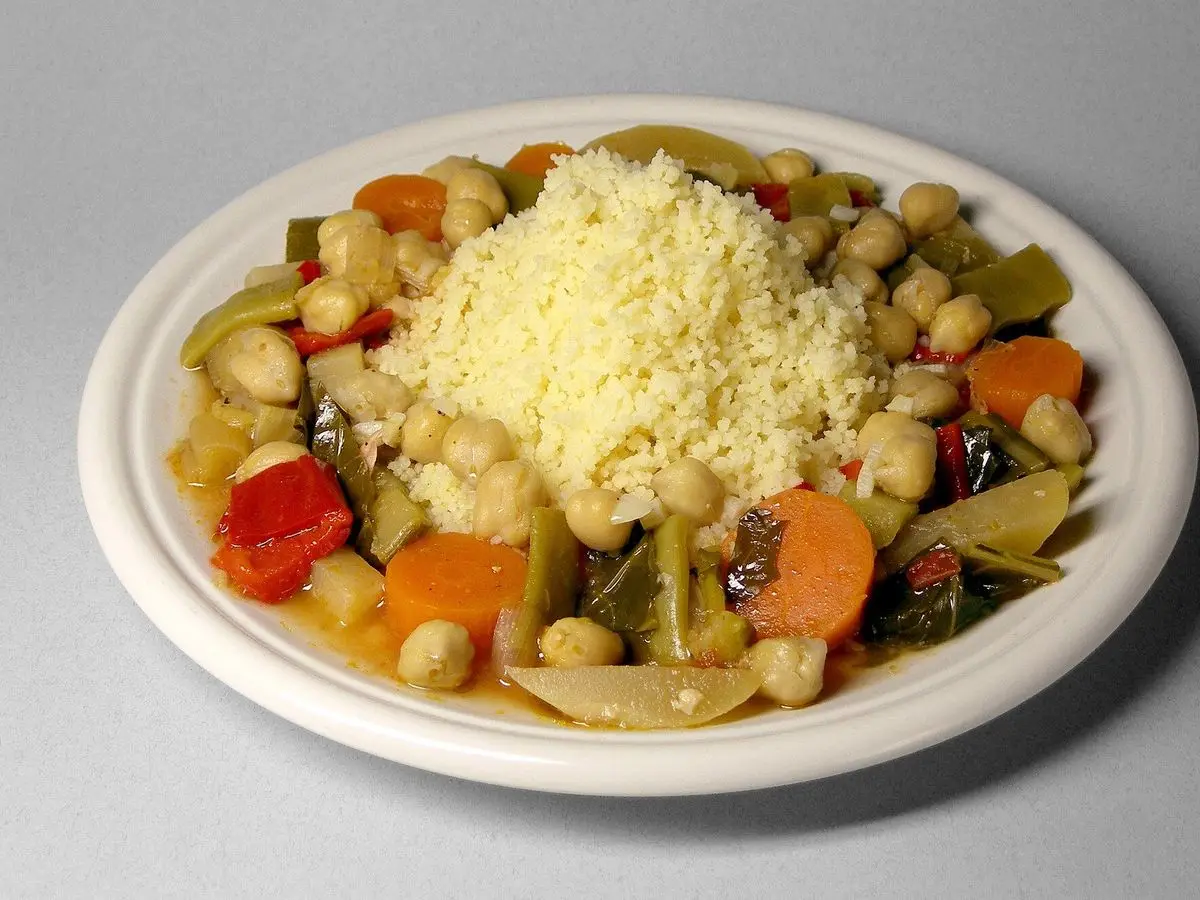 Plato de cuscús con garbanzos, pimiento rojo, zanahoria y verduras salteadas