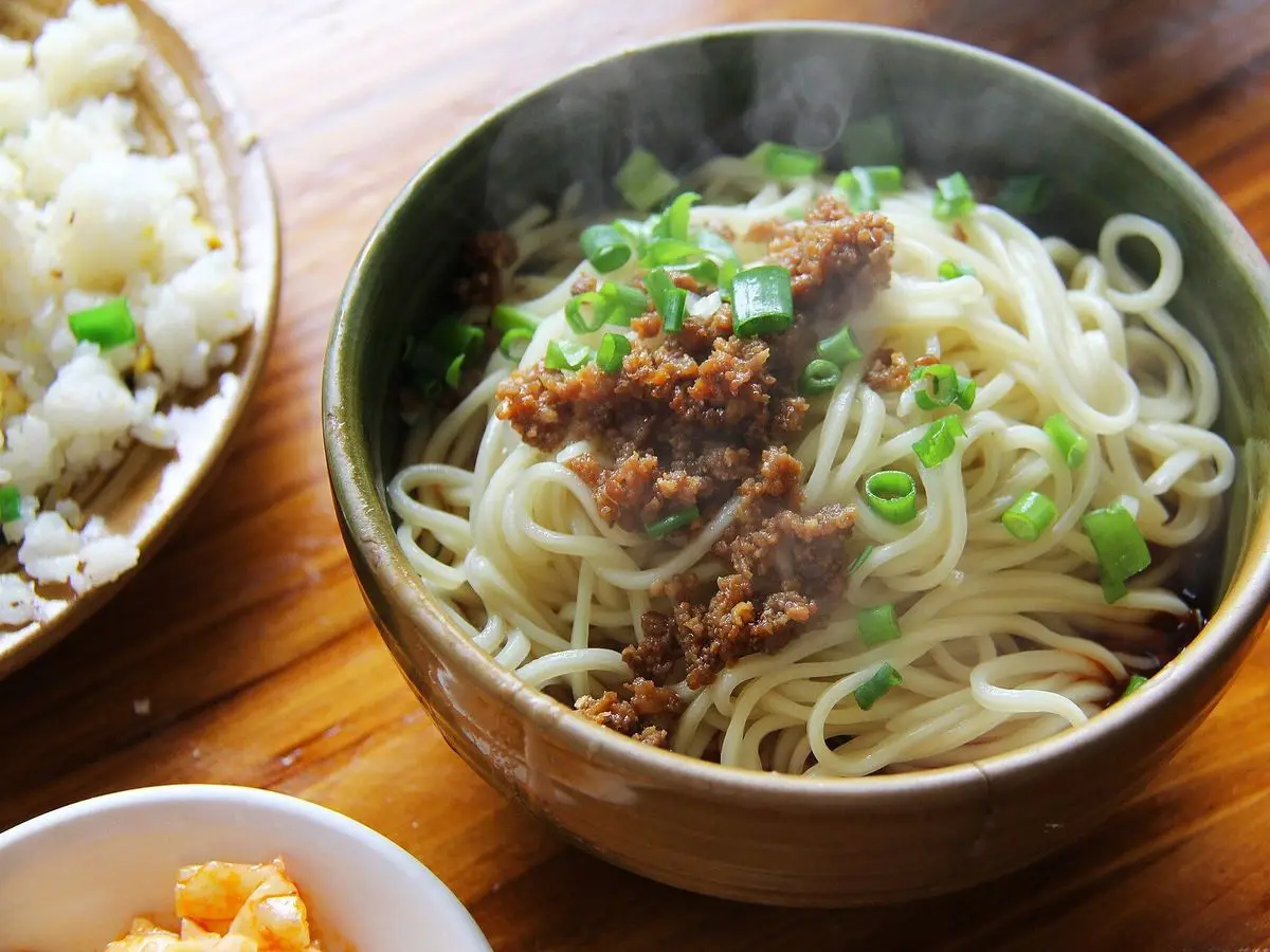 Cuenco de fideos con carne de cerdo picada y cebolleta picada