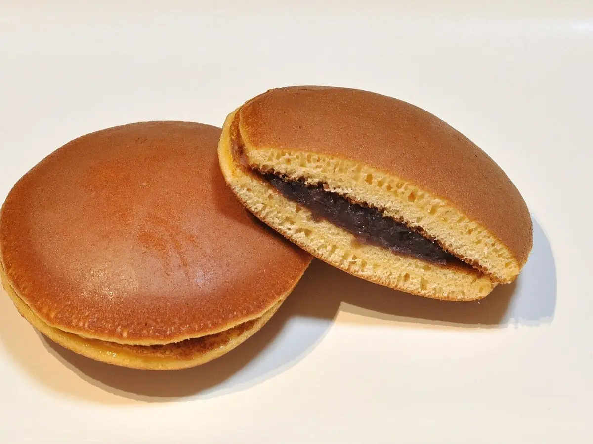 Dos dorayaki, uno entero y otro abierto que muestra el relleno oscuro de pasta de judías