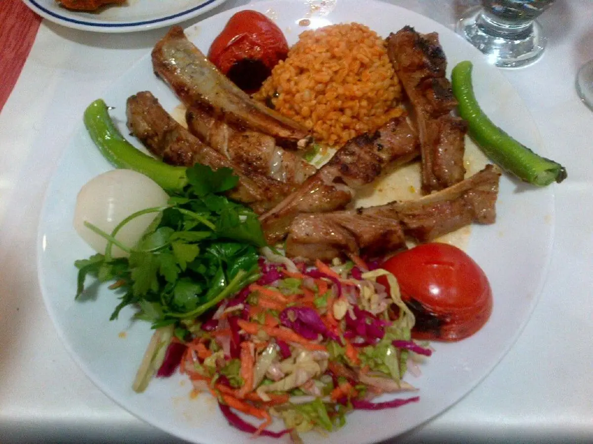 Plato con carne a la plancha, bulgur, tomate, pimiento verde y ensalada de col
