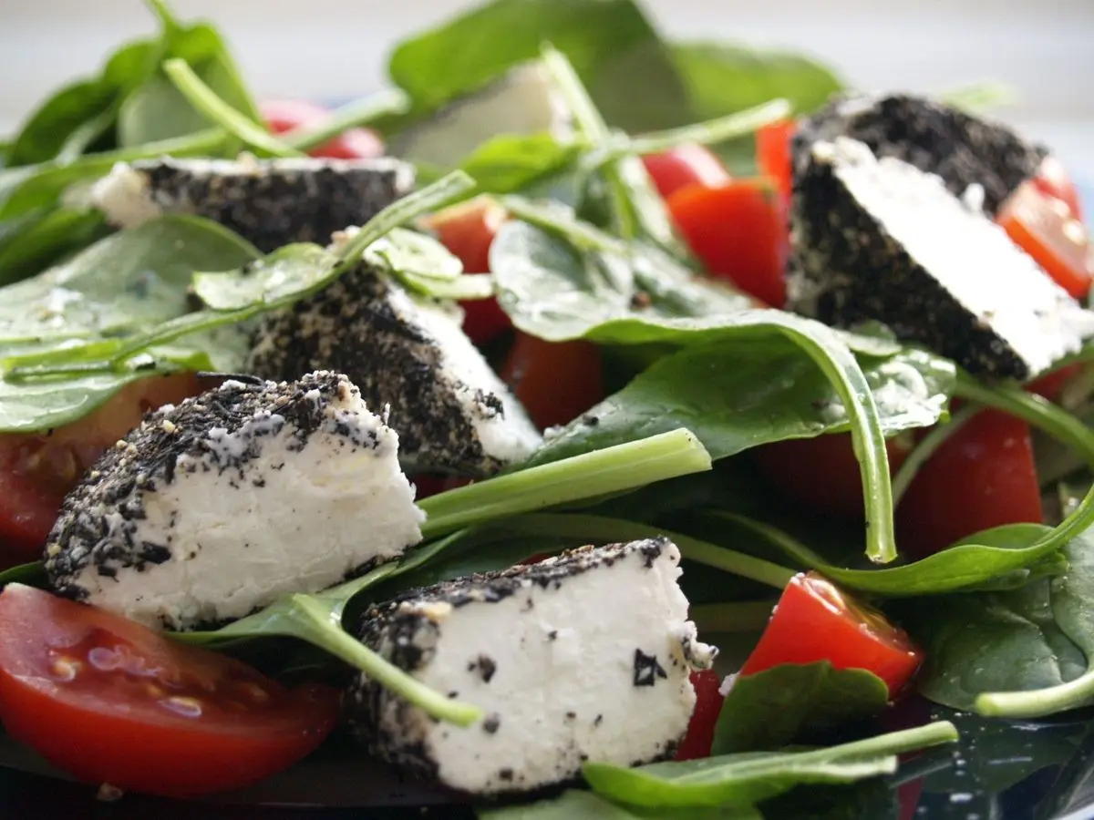 Ensalada de espinacas con tomate y dados de queso de cabra con semillas negras