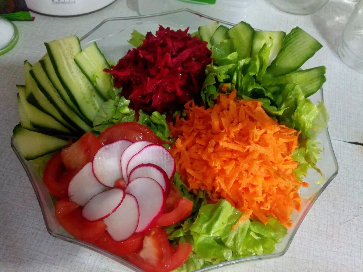 Fuente de cristal con remolacha y zanahoria rallada, pepino, lechuga, rabanitos y tomate