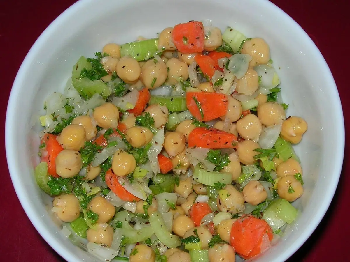Ensalada de garbanzos con zanahoria, apio y lechuga en un plato hondo blanco