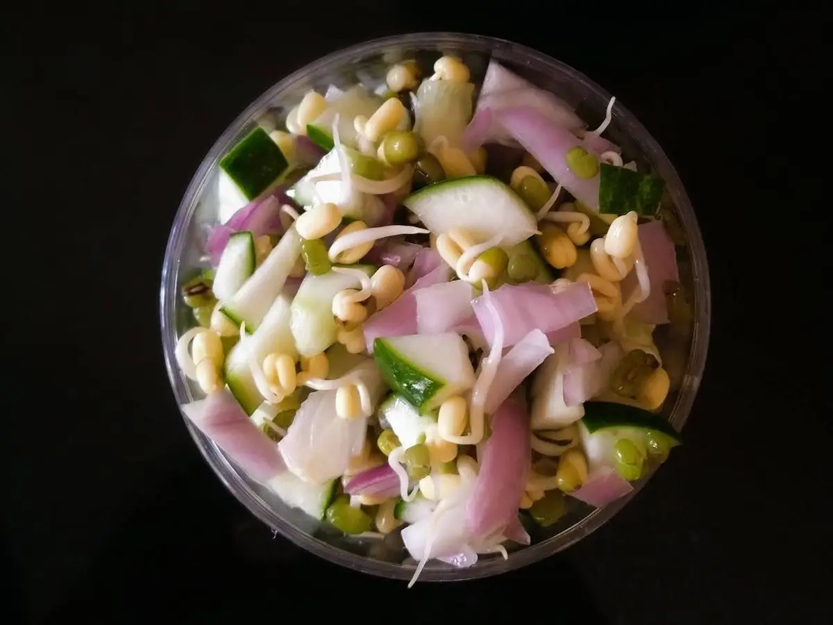 Cuenco transparente con brotes de soja, pepino y cebolla morada en rodajas