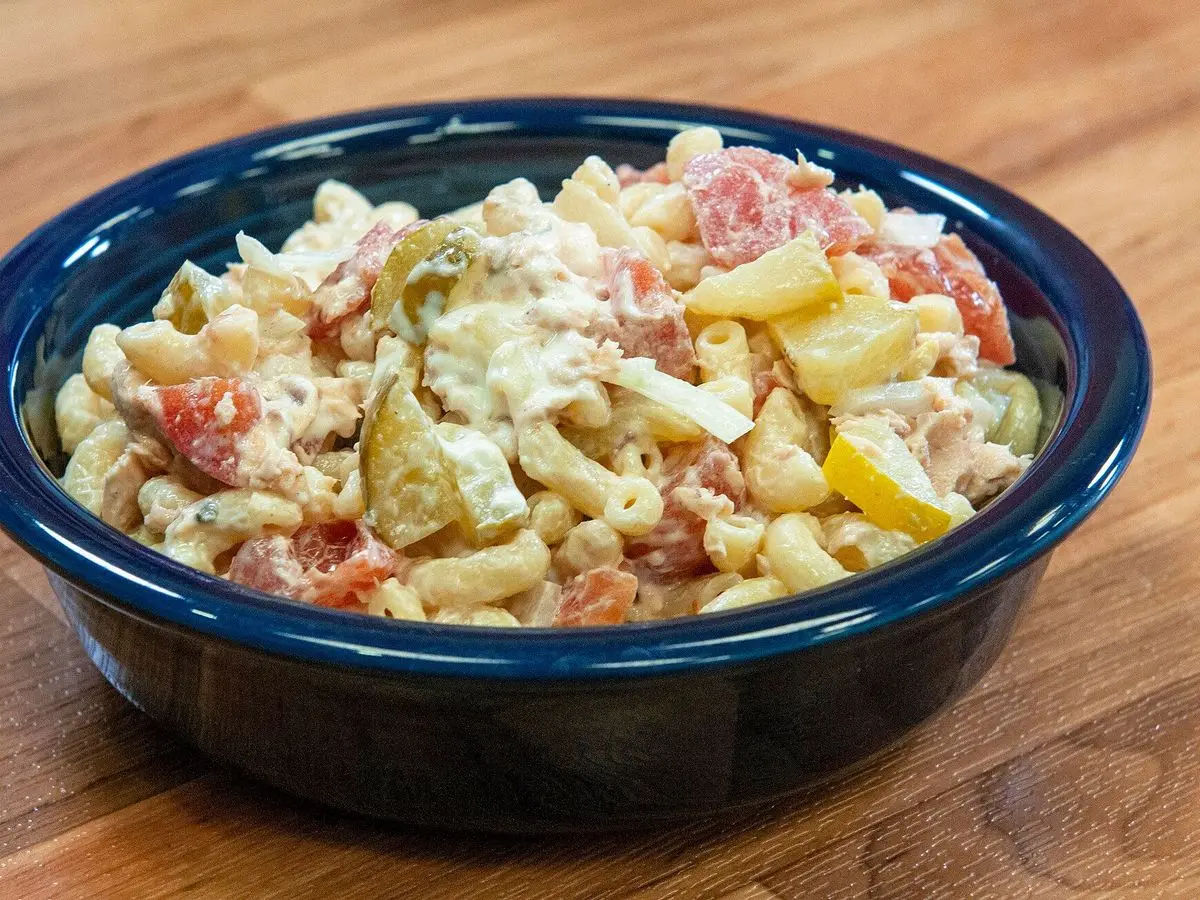 Cuenco azul con ensalada de macarrones con tomate, jamón y verduras en dados