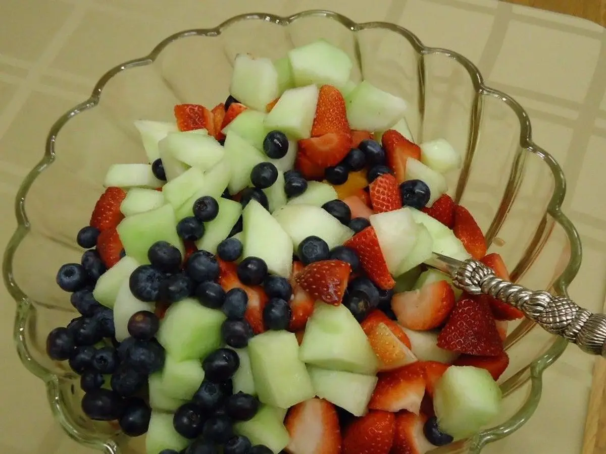 Cuenco de cristal con macedonia de melón, arándanos y fresas