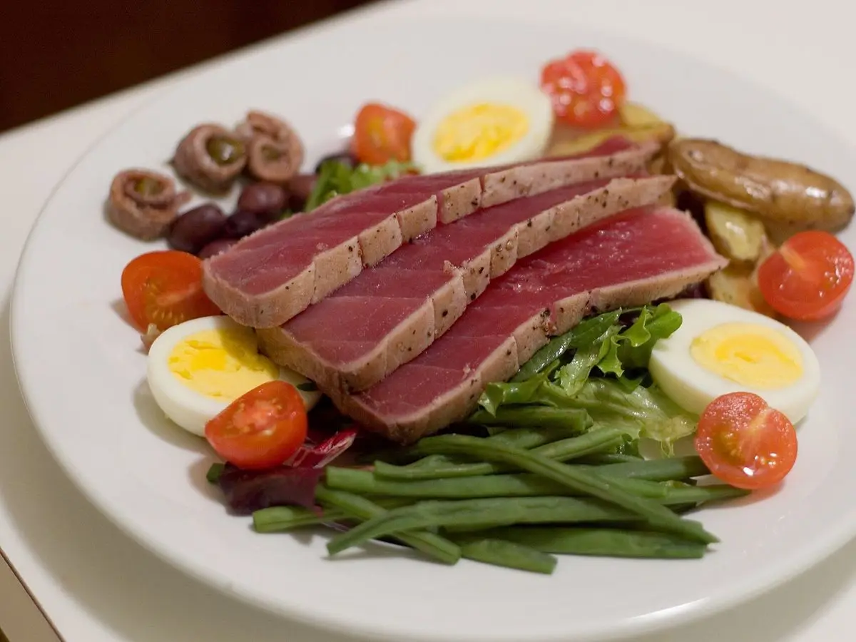 Ensalada niçoise con lonchas de atún sellado, judías verdes, huevo duro y tomate cherry