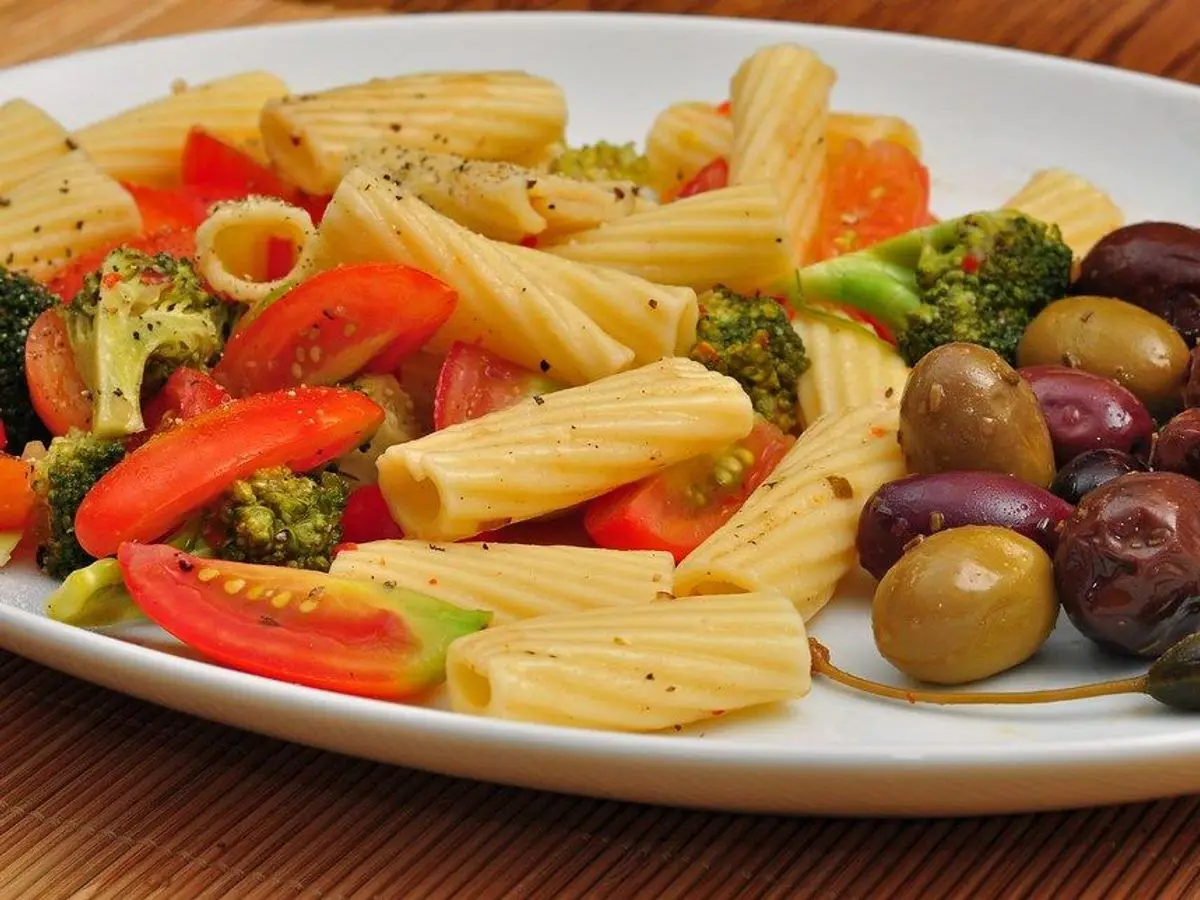 Plato con pasta, brócoli, tomate asado y aceitunas negras
