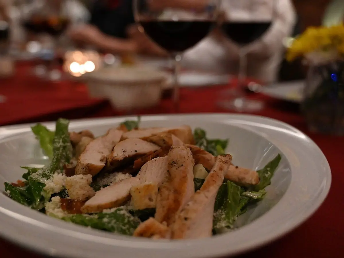 Cuenco con ensalada de hojas verdes y tiras de pechuga de pollo a la plancha