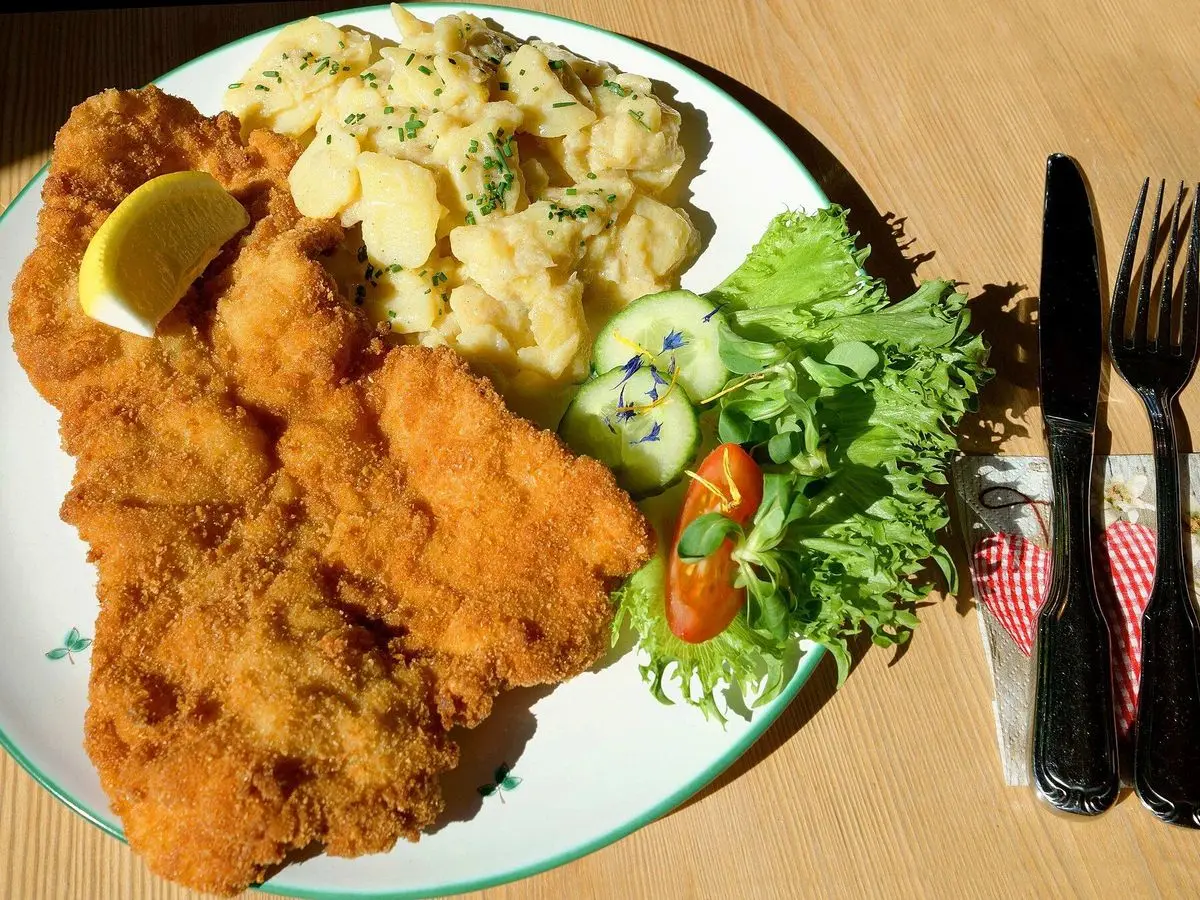 Escalope empanado con ensalada de patata, pepino, tomate y lechuga y rodaja de limón