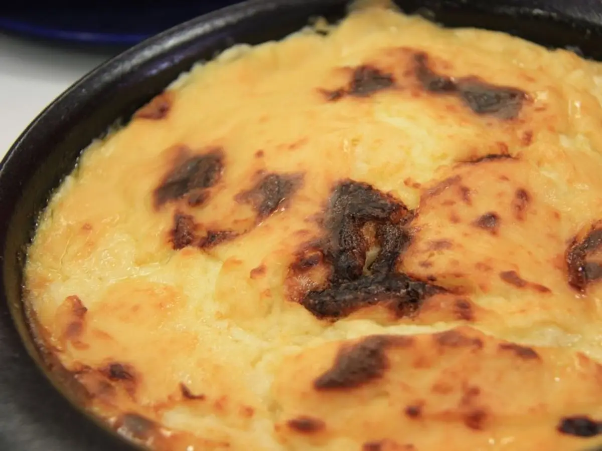 Fuente negra con un gratinado de puré y bacalao dorado y tostado por encima