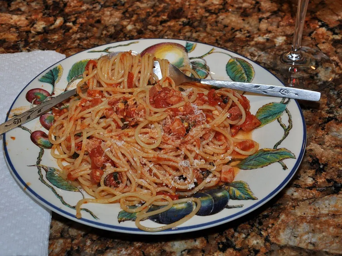 Espaguetis con salsa de tomate en un plato de cerámica decorado