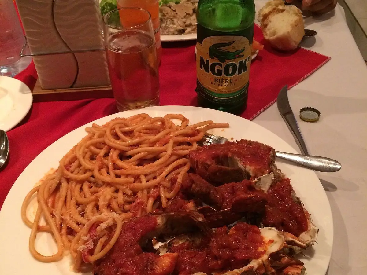 Plato de espaguetis con salsa roja y trozos de crustáceo