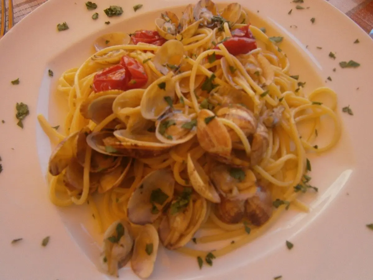 Plato de espaguetis con almejas, tomate cherry y perejil picado